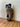 African-style mask on a wooden surface with a white wall background